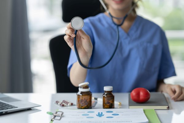 Confident doctor with medical stethoscope holding red heart with Confident doctor with medical stethoscope holding red heart with electrocardiogram. Control pills. Treatment. Treatment concept. Planning for heart disease, medication, life insurance.